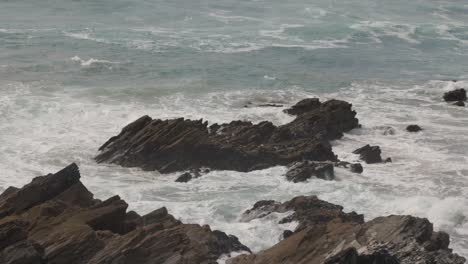 disparo en cámara lenta de las olas chocando contra las rocas de la costa de newquay