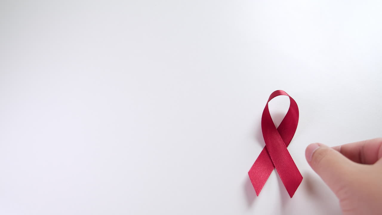 Placing a red ribbon on the right side of the frame which signifies the HIV-AIDS worldwide disease awareness and prevention.