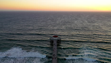 Aerial-flyover-shot-of-Manhattan-Beach-coastline-at-sunset,-California,-USA