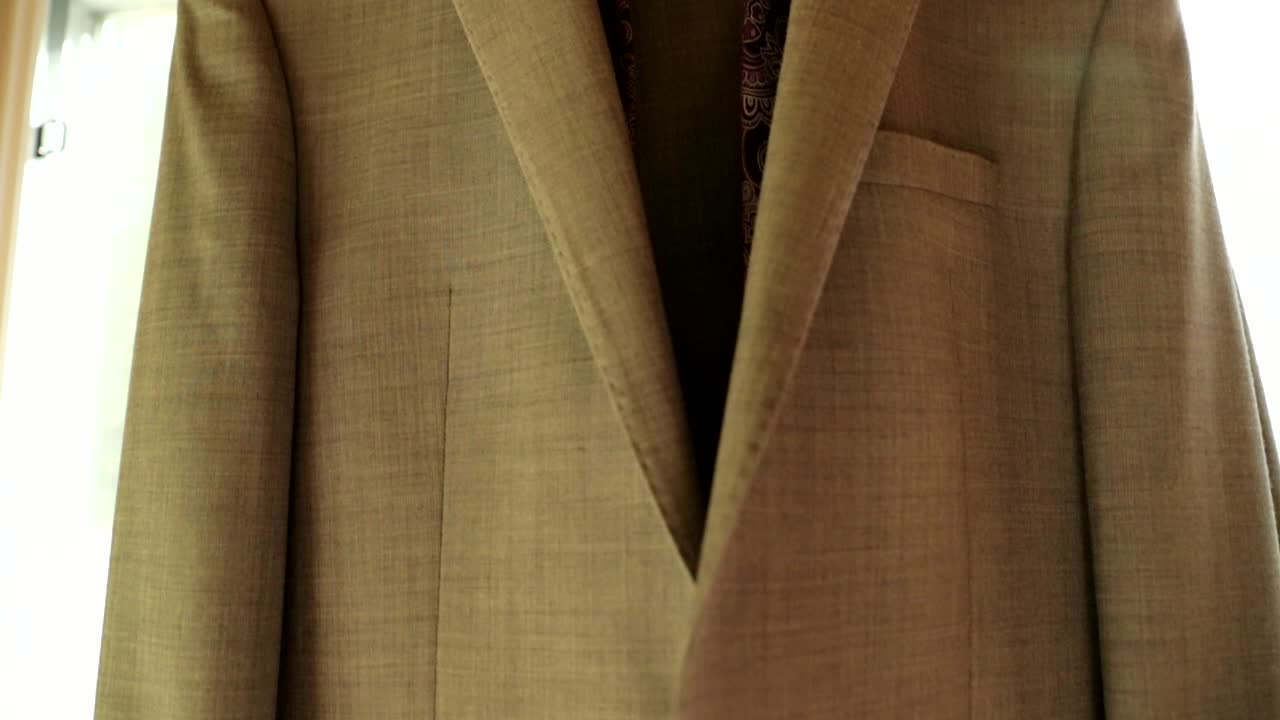 그가 결혼식을 준비하기 전에 신랑 황갈색 정장과 창에 걸려 보라색 넥타이