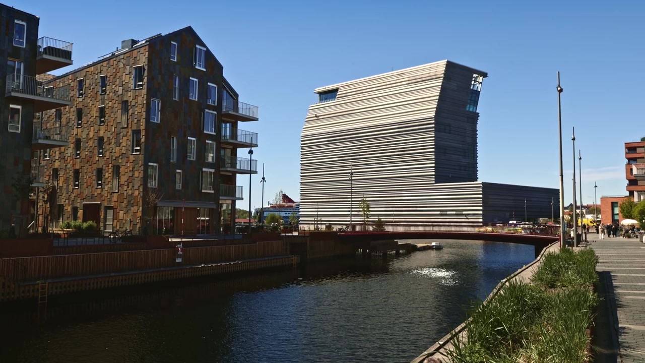 Distrito portuário de Bjørvika em Oslo, Noruega, apresentando edifícios modernos ao longo de um canal e o icónico Museu Munch