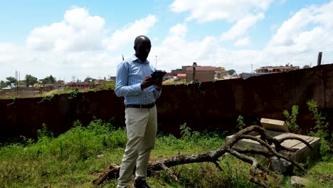 an african drone pilot flying drone in rural africa