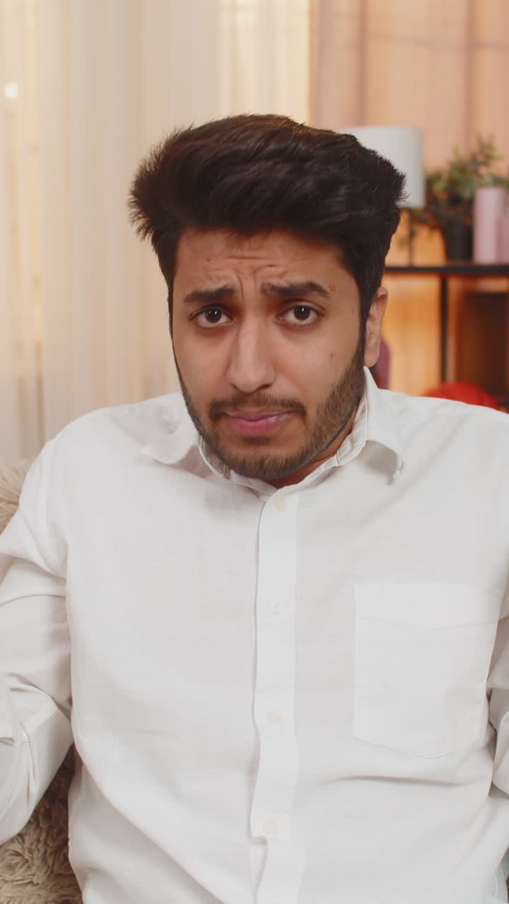 Indian young man surprised raising hands in confusion making what why gesture questioning reaction