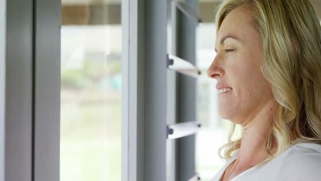 mujer estirando los brazos cerca de la ventana 4k