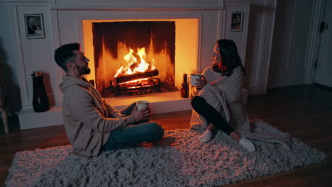 una pareja relajándose junto a la chimenea.