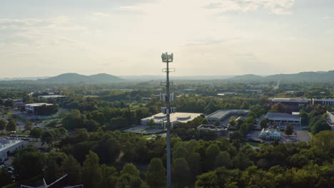 aerial orbiting 5g cell phone radio communication tower in suburban area, 4k