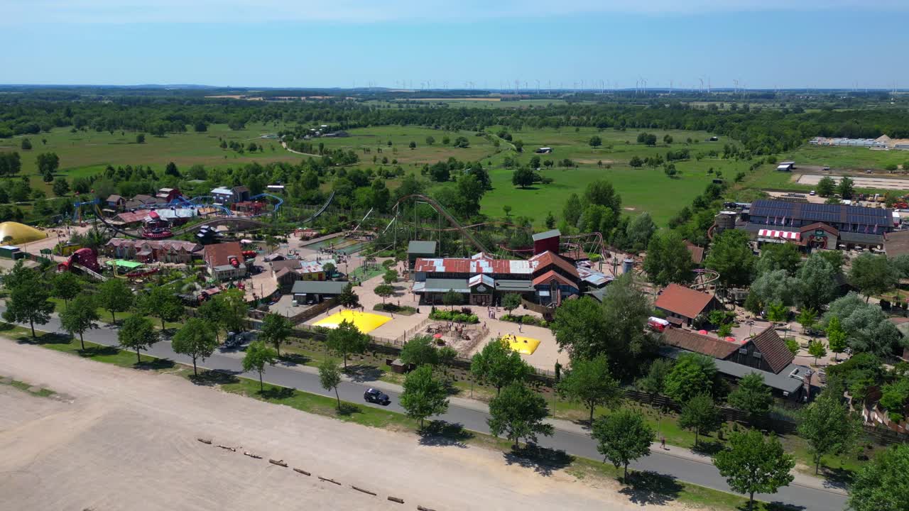 Amusement park with roller coasters, various attractions, and green spaces in Germany. speed ramp hyper motion time lapse. Great aerial view flight wide orbit overview drone