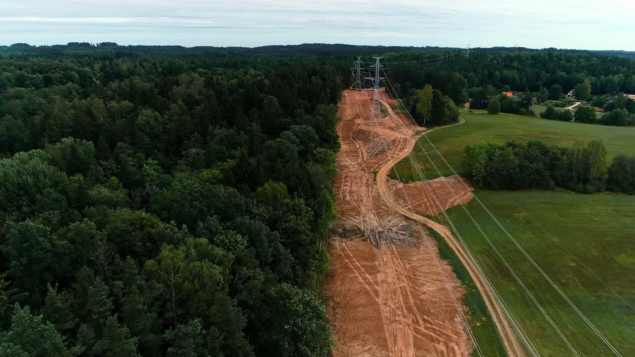электрические линии и вышки рядом с густым лесом в сельском ландшафте