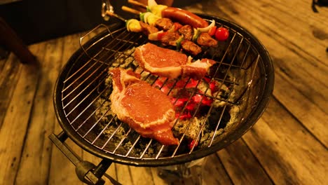 steaks and vegetables cooking on a charcoal grill