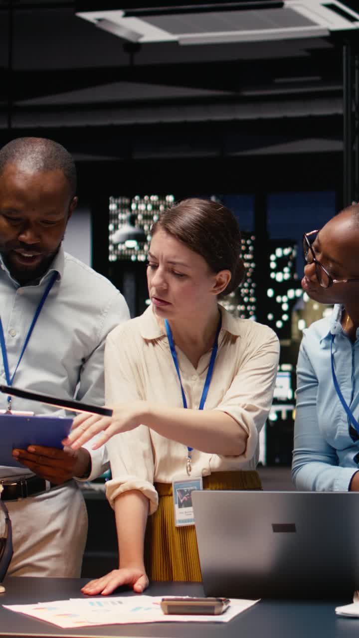Vertical Video Portrait of colleagues engaged in teamwork during late night briefing session