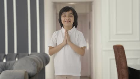 happy indian boy doing namaste