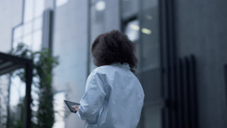 Portrait-manager-touching-tablet-screen-working-outdoors-remotely-at-downtown.