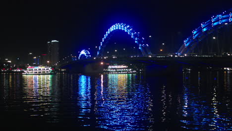 Vista-Nocturna-Del-Puente-Del-Dragón-En-La-Ciudad-De-Da-Nang-De-Vietnam-Construida-Sobre-El-Río-Han-Y-Crucero-Navegando-A-Través