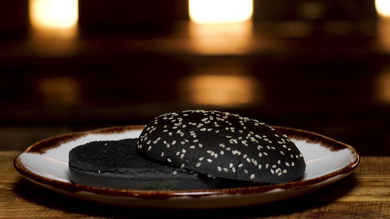 primer plano de una hamburguesa de semilla de sésamo negra en un plato