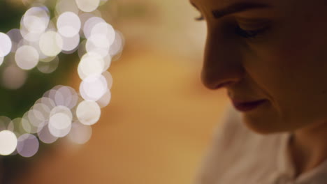 woman untangles lights in warm christmas interior