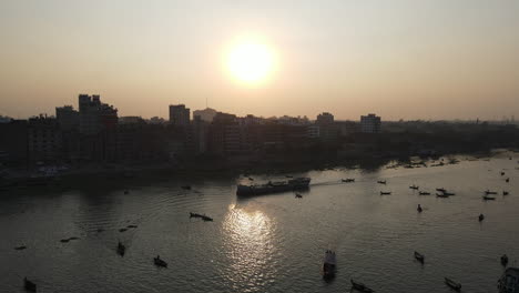 buriganga river port beside city in sunrise with boats - aerial establishing drone flight shot