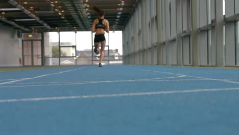 mujer compitiendo en pista cubierta