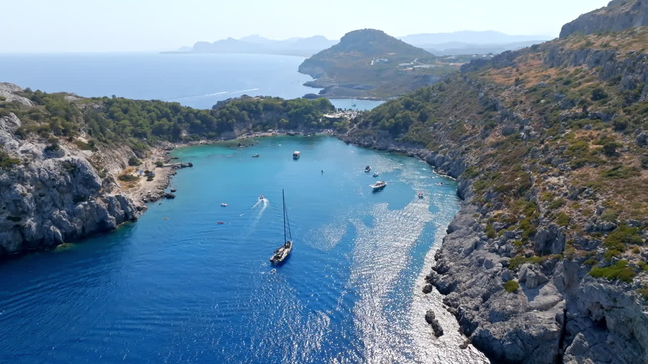 Panoramic drone shot circling boats at the Anthony Quinn bay, in sunny Rhodes