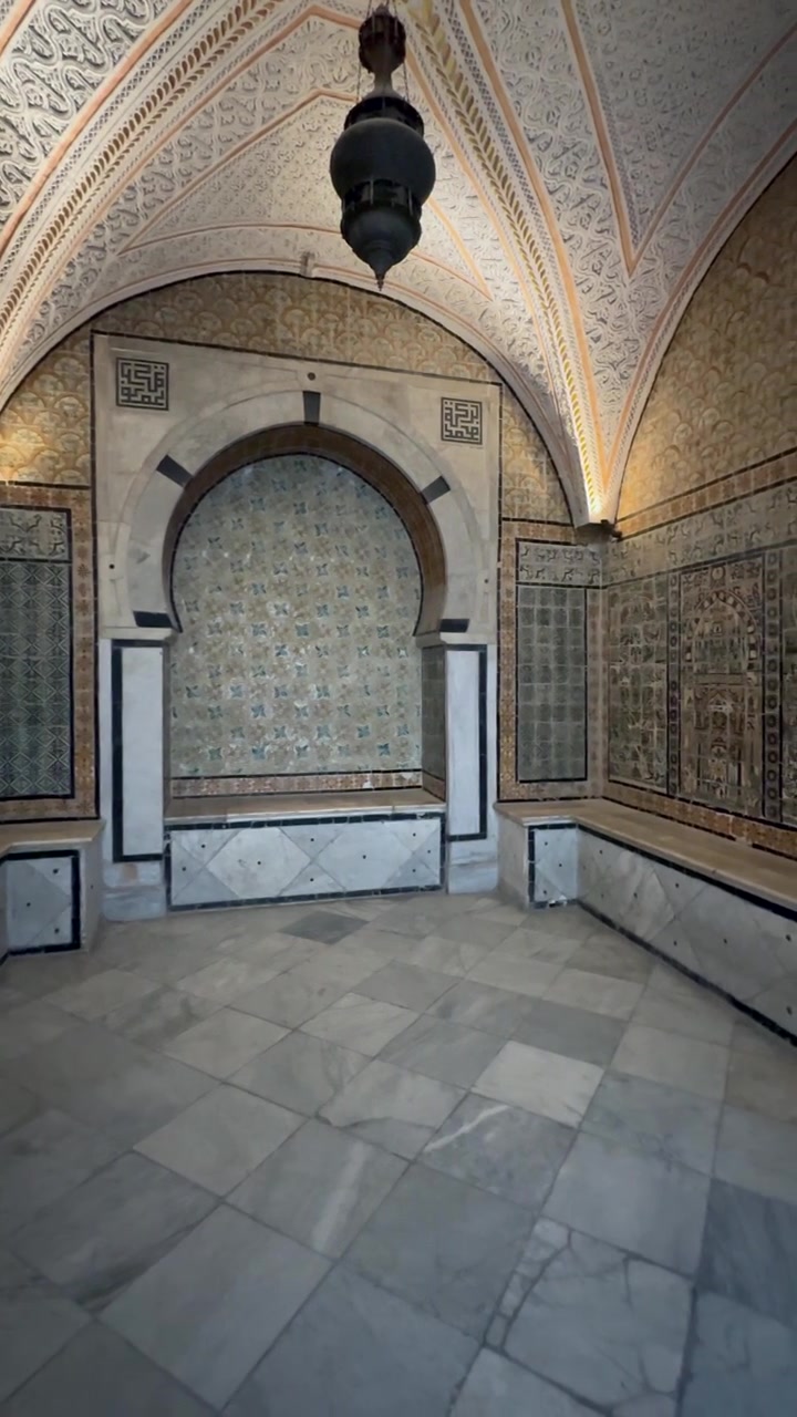 Sala in marmo decorata con piastrelle geometriche islamiche, nicchia ad arco e panche in pietra nel Museo Nazionale del Bardo, Tunisia.
