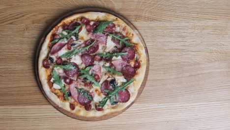 vista superior de la pizza apetitosa en una tabla de madera en un restaurante