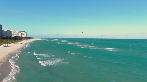 tourists parasailing on the midbeach section of miami beach, florida, united states