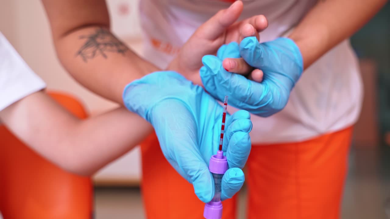 Nurse in collecting blood of a child's finger. Close-up of a medical technician in sterile gloves taking a sample of blood from patient's finger. Healthcare concept.