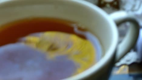 los hermosos reflejos de un árbol en una taza de té y gotas de té cayendo