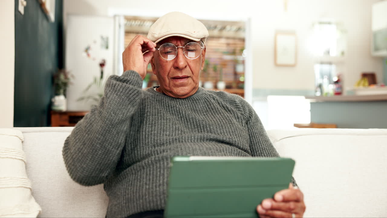 Senior man reading on tablet at home