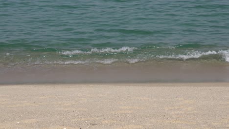 Schaumige-Wellen-Waschen-Weißen-Sandstrand-In-Gangneung,-Südkorea---Nahaufnahme