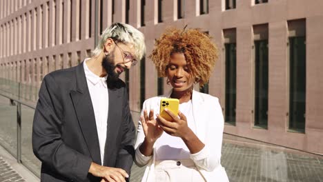 two business colleagues using a smartphone outdoors
