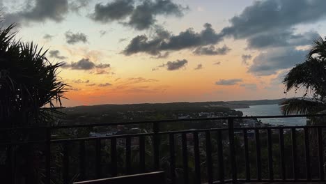 an incredible tropical golden and pink sunset from a high lookout of the famous tourist beach town of pipa, brazil in rio grande do norte surrounded by green foliage during a warm summer evening