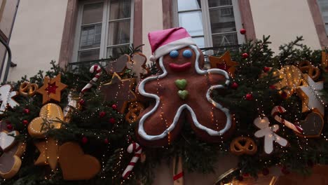 ginger bread man decorations on storefront decorations at festive christmas market in strasbourg, france europe