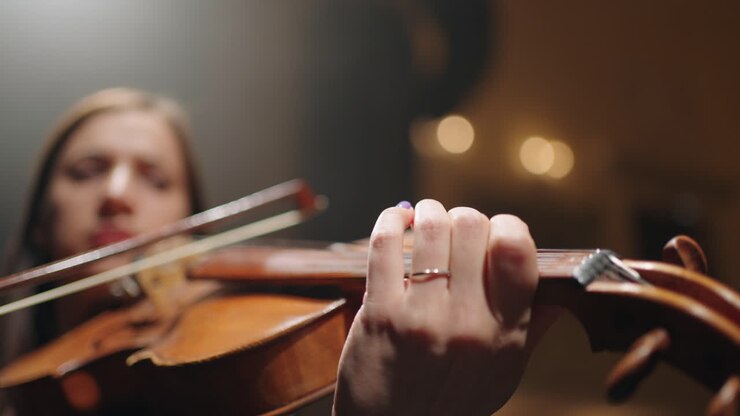 primo violino in orchestra vista ravvicinata del violino nelle mani di una musicista donna concerto o prova in un teatro dell'opera