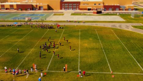 effetto tilt shift in miniatura di una partita di calcio giovanile in una scuola nella periferia americana