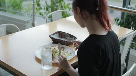 girl eating salad in cafe