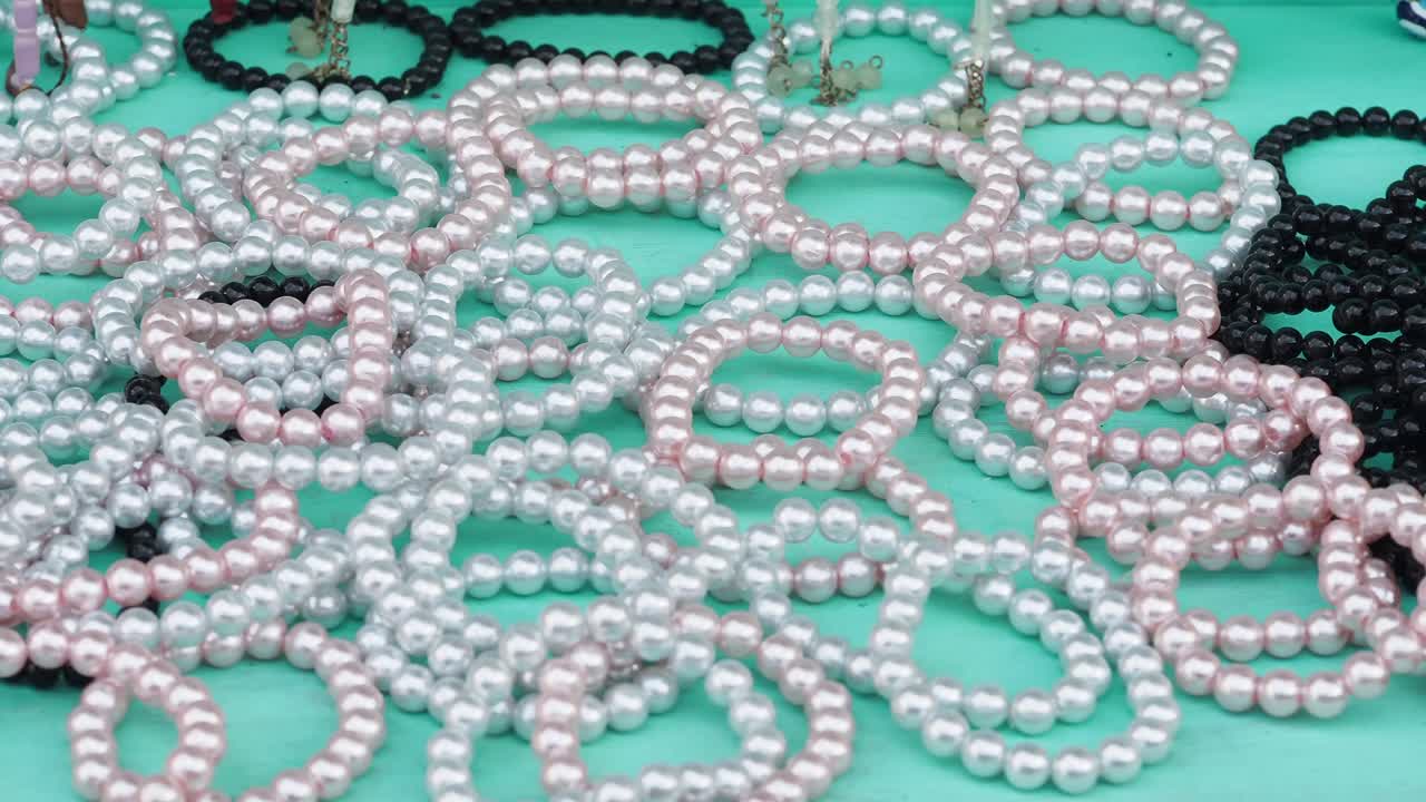 Colorful Pearl Bracelets Displayed on Turquoise Surface