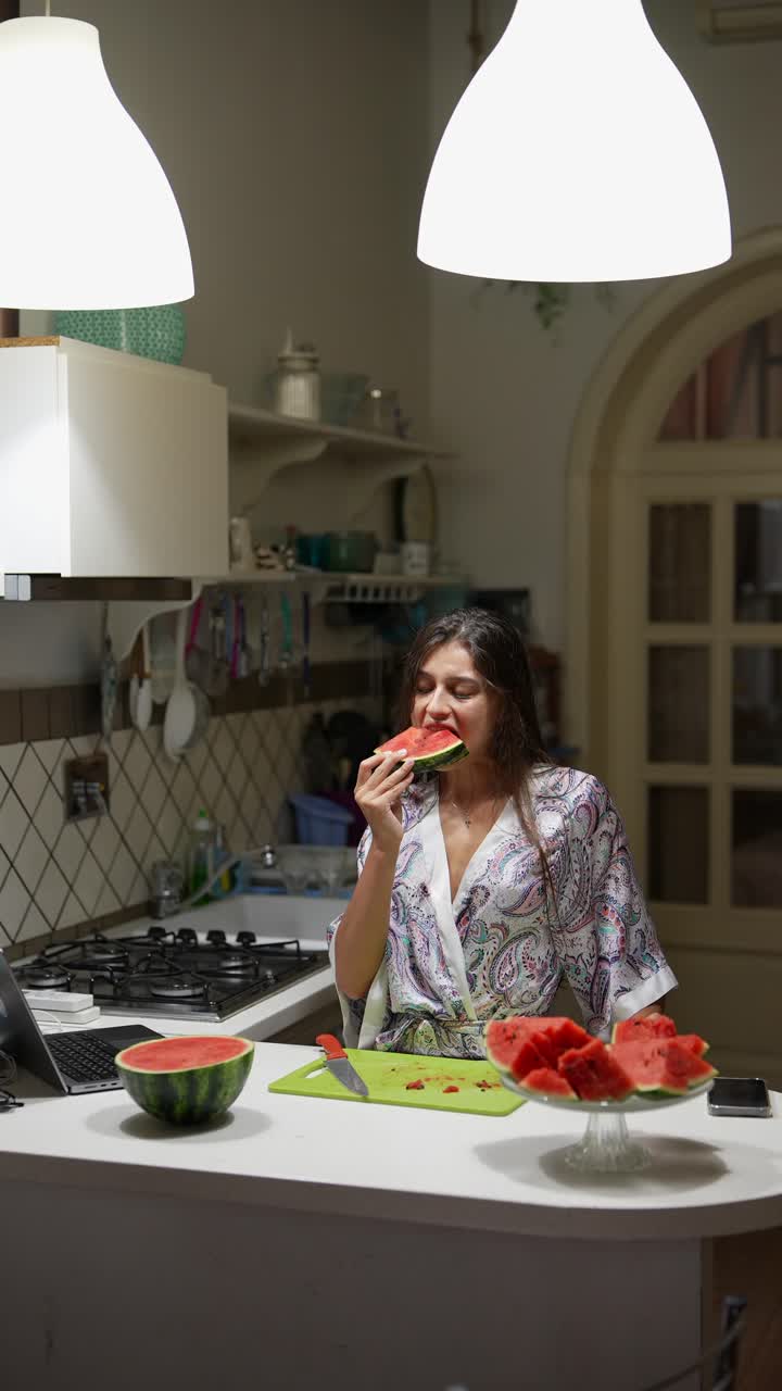 mujer comiendo sandía en la cocina