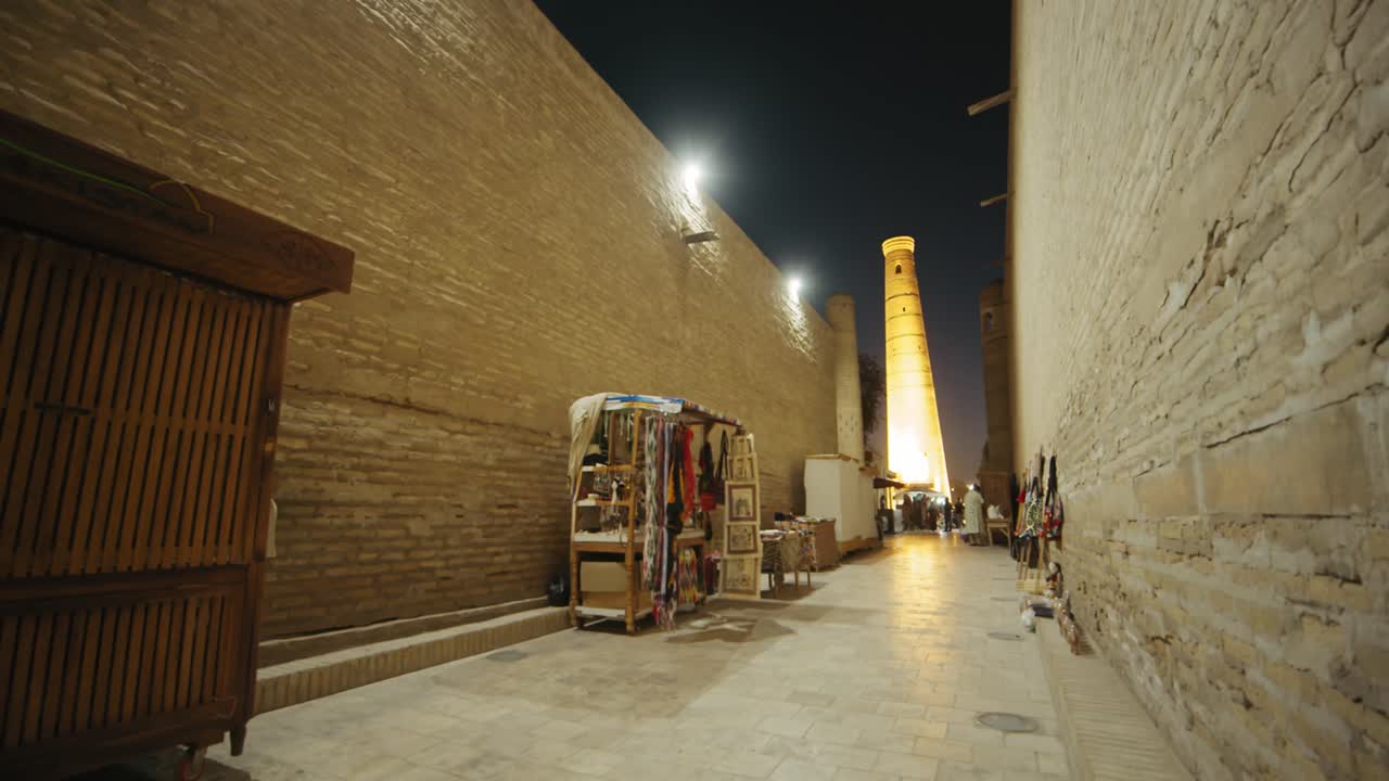 Khiva Minaret merchants' stalls on the street of the ancient city in the evening. Ichan Kala Fortress Uzbekistan