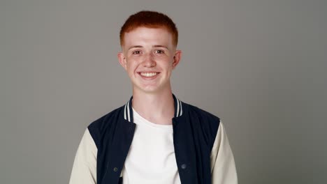 portrait of red head caucasian teenage man with toothy smile