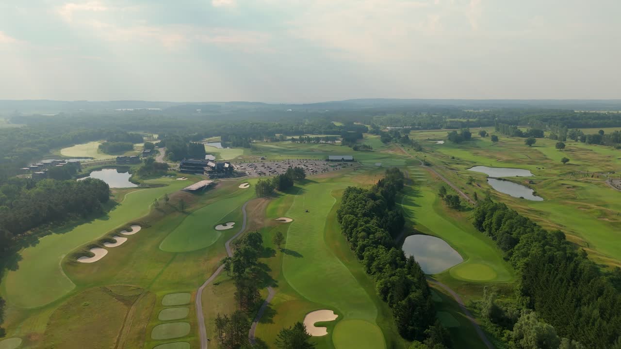 Wide drone shot of TPC Toronto at Osprey Valley, highlighting fairways, bunkers, ponds, clubhouse activity, and the expansive tournament-ready course layout