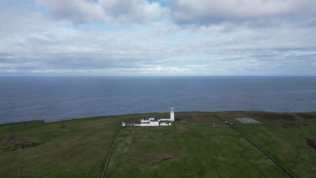 faro de loophead en un acantilado con mar y cielo expansivos, vista aérea
