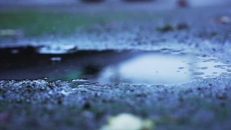 Zwei-Große-Wassertropfen,-Die-In-Einer-Pfütze-Auf-Den-Beton-Fallen