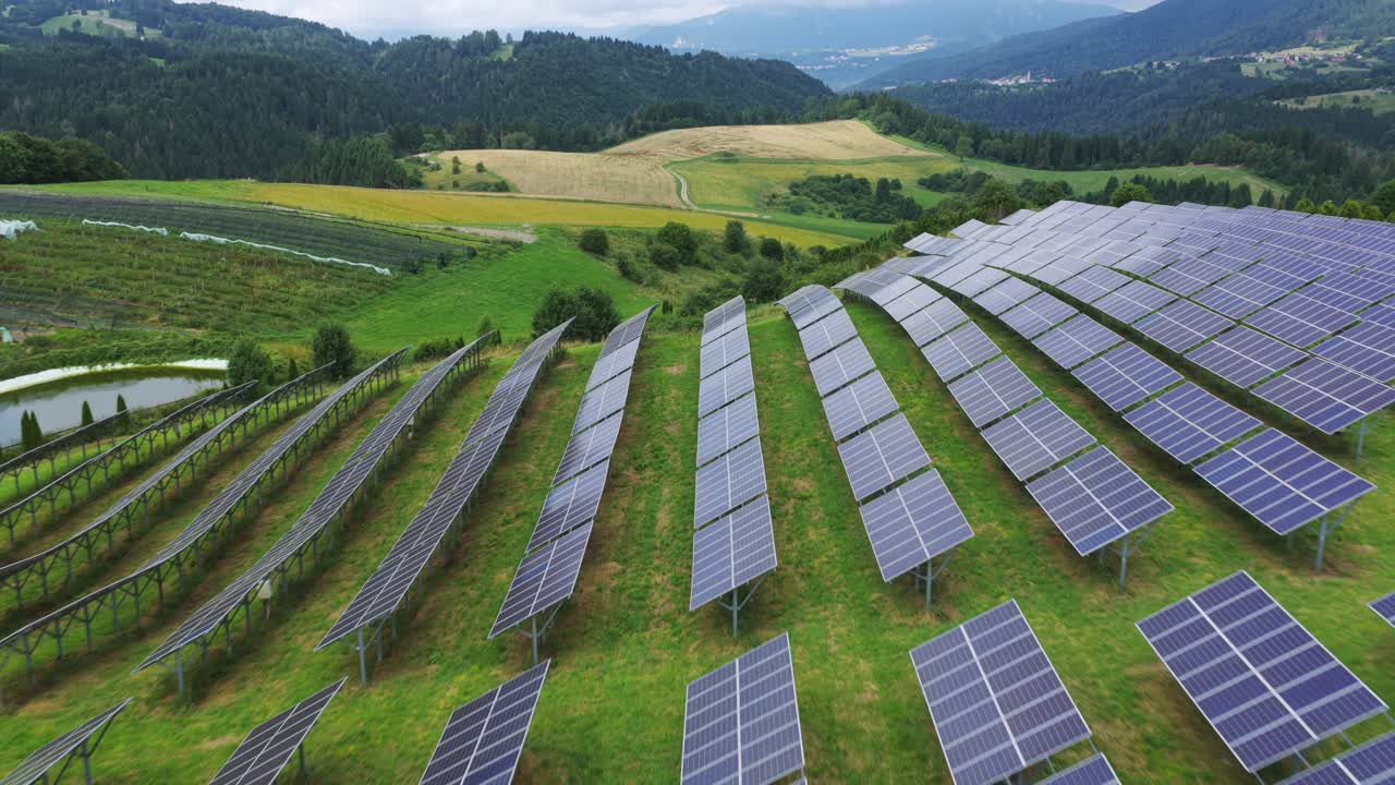 Large solar farm with photovoltaic panels on rural hillside, Roana, Italy. Aerial forward