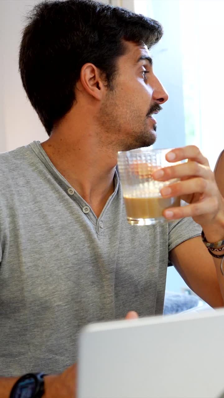 Couple having breakfast with laptop