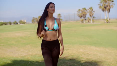 pensive woman in beach wear at grassy landscape