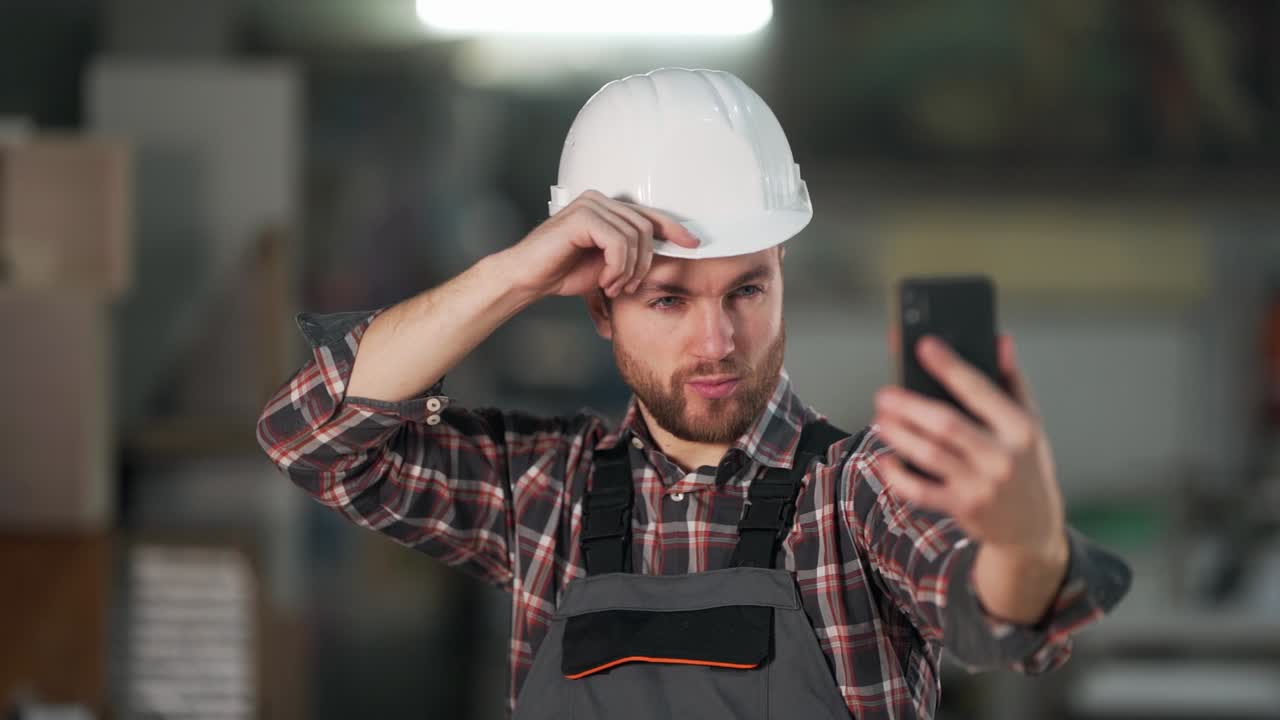 homem barbudo de uniforme de trabalho tirando uma selfie no telefone