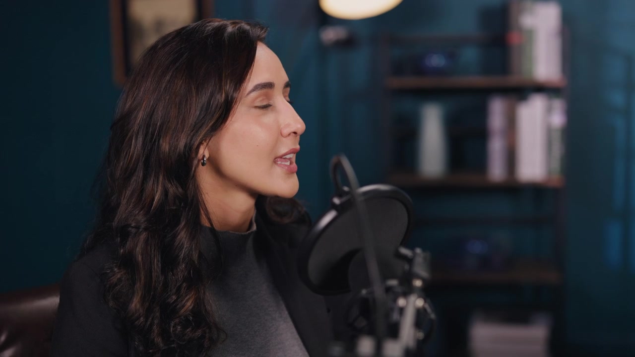 Giovane donna che parla al microfono in uno studio professionale