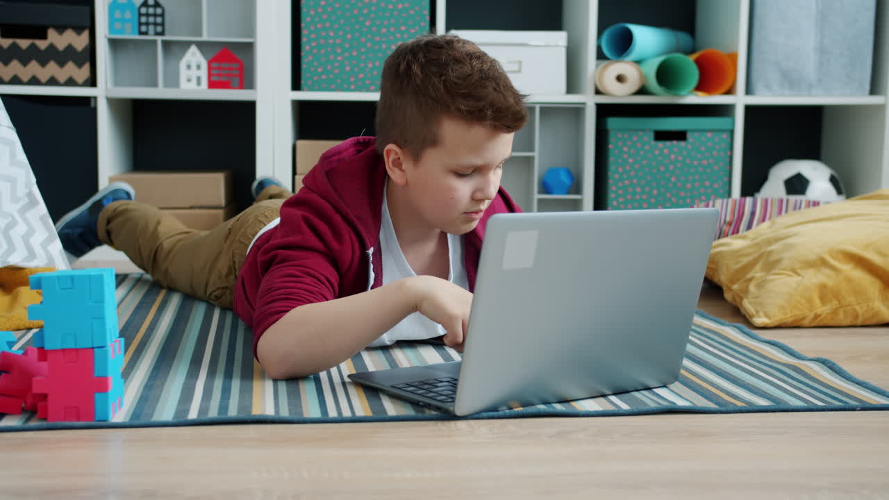 Boy Lying on Floor Using Laptop
