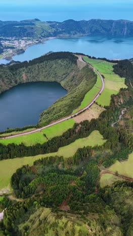 flight over the mount approaching the lake in volcano crater. amazing scenery of the azorean islands from top. vertical video.