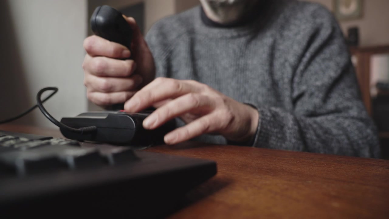 Primo piano di un utente che utilizza un joystick e una tastiera, suggerendo lo sviluppo di giochi, il testing di software, gli esports e la tecnologia interattiva.